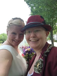 Picture of Crystal in a wedding gown, Nóirín dressed in a fancy red jacket and hat.