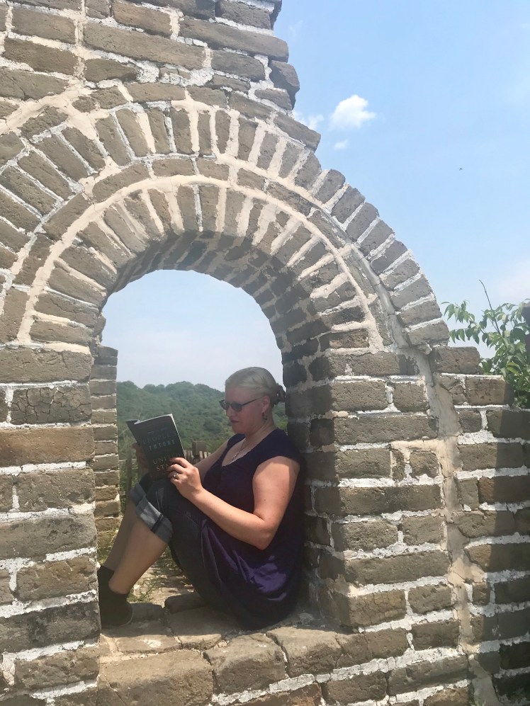 This is a photo of me sitting on the Great Wall of China, reading A People's Future of the United States.